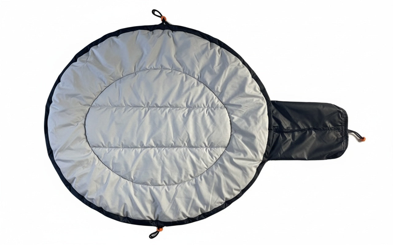 Round quilted cosy dog bed with black border and pack down bag attached on a white background