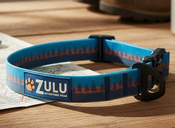 Blue and orange waterproof dog collar with pine trees around it and ZULU adventure wear on the label. 